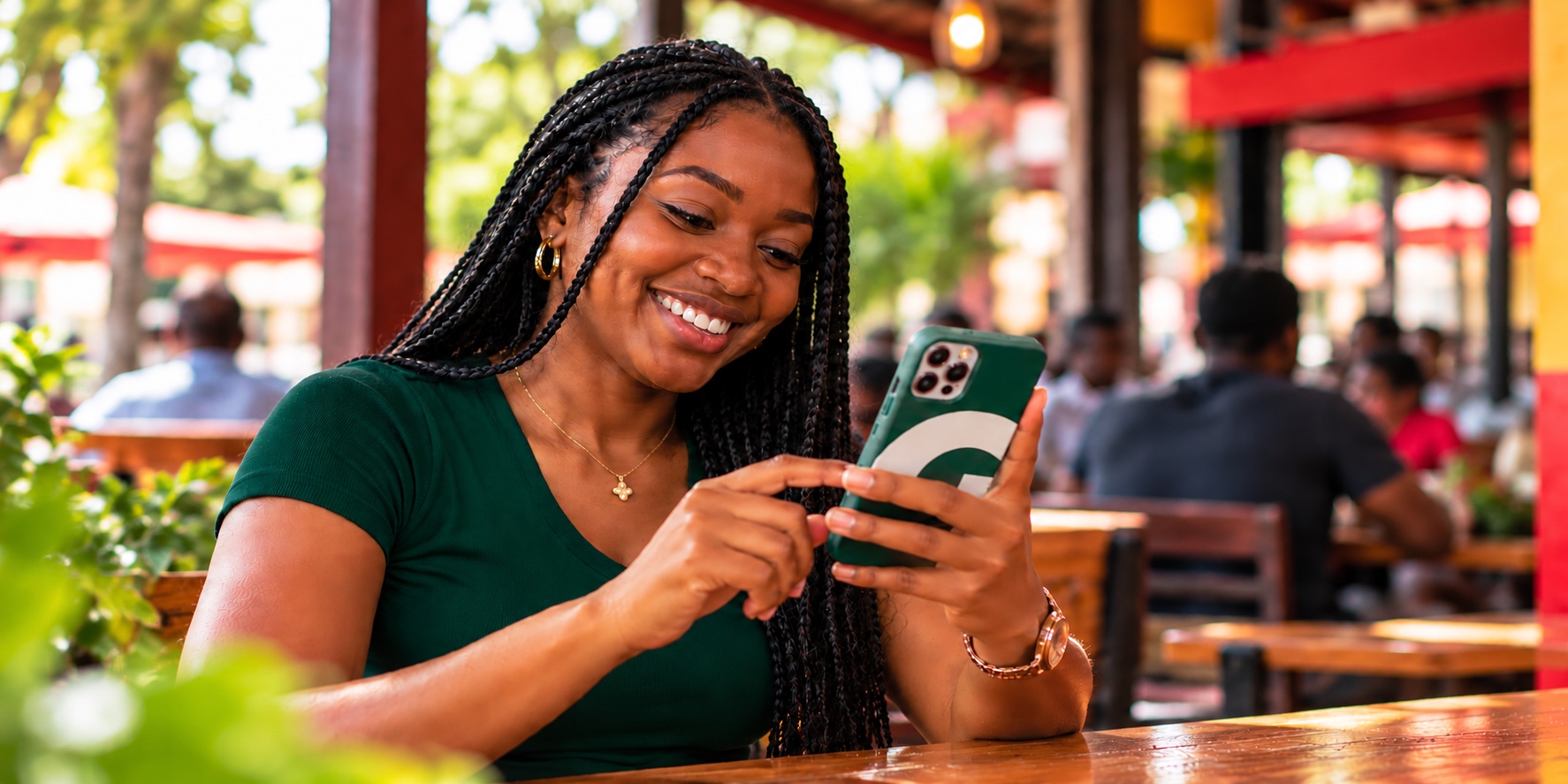 Woman using her phone at a local restaurant while exploring fufu places in Kumasi